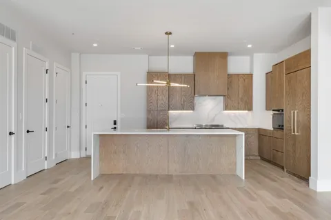 a large kitchen with kitchen island a sink stainless steel appliances and cabinets