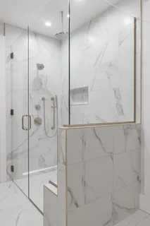 a bathroom with a glass shower door and a shower