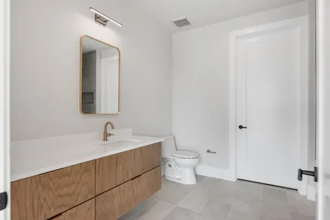 a bathroom with a toilet a sink and mirror