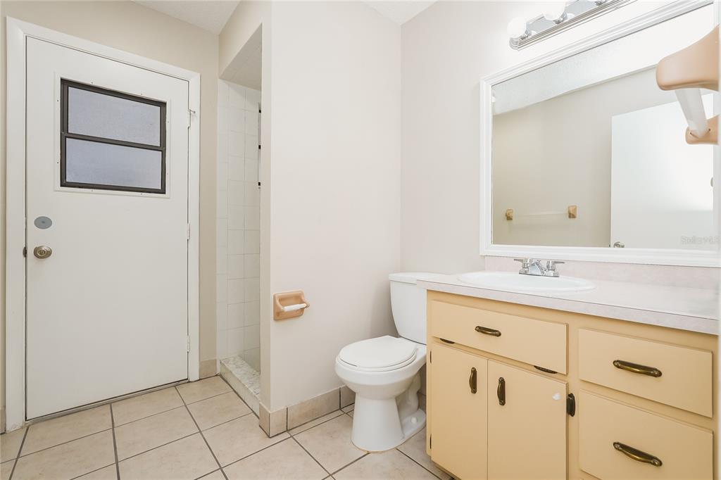12165 Rockford Street Spring Hill, FL 34608 - Photo 12 of 16 a bathroom with a granite countertop toilet a sink and a mirror