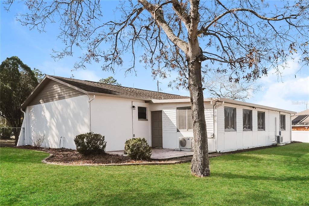 12165 Rockford Street Spring Hill, FL 34608 - Photo 16 of 16 a backyard of a house with plants and large tree