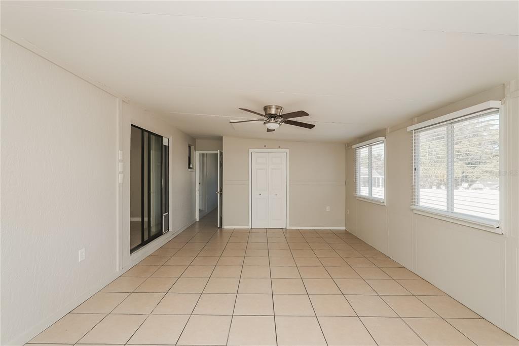 12165 Rockford Street Spring Hill, FL 34608 - Photo 9 of 16 a view of an empty room with window and chandelier fan