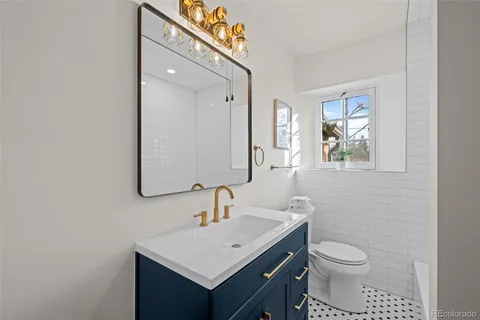 a bathroom with a toilet a sink a mirror and vanity