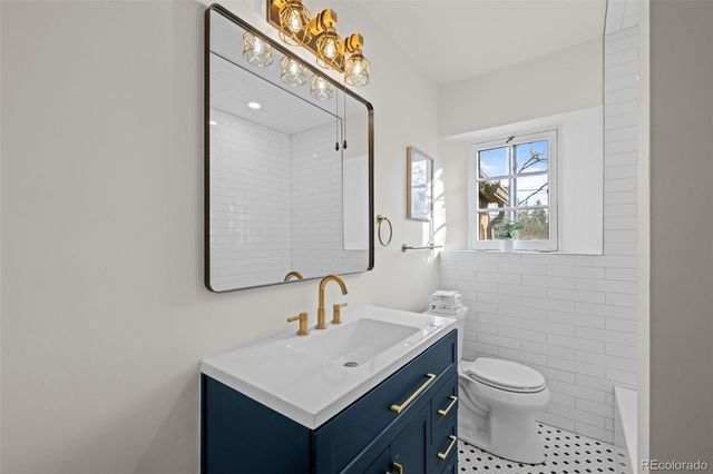 a bathroom with a toilet a sink a mirror and vanity