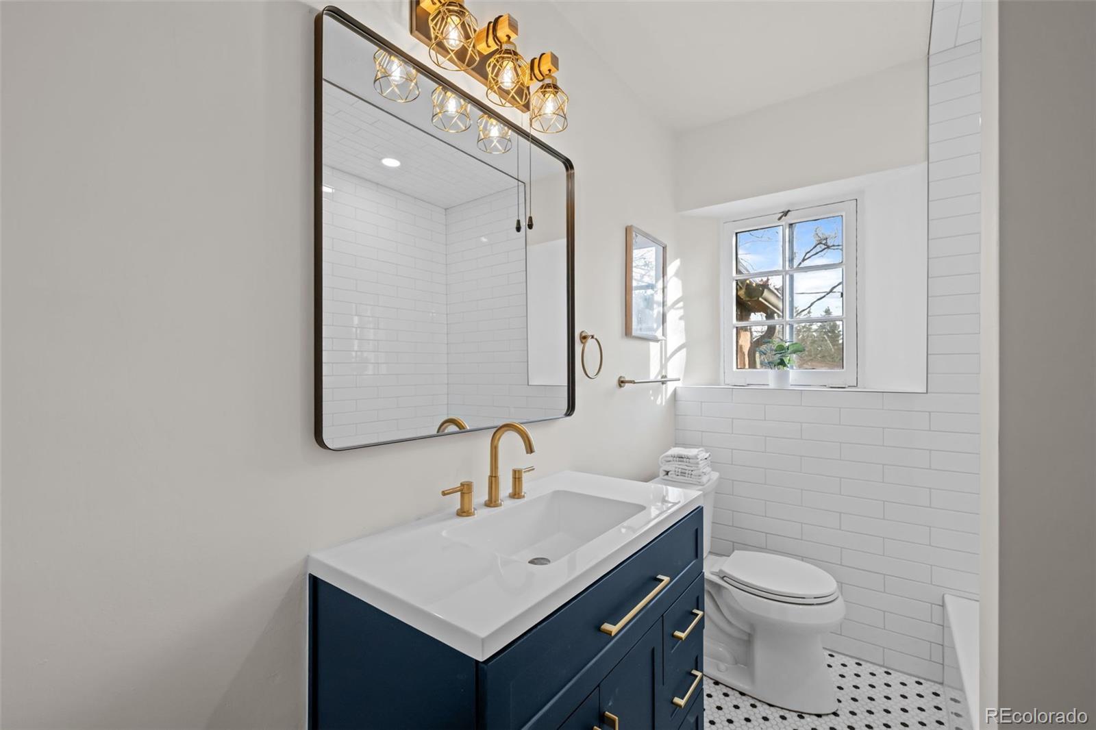 772 16th Street Boulder, CO 80302 - Photo 14 of 26 a bathroom with a toilet a sink a mirror and vanity