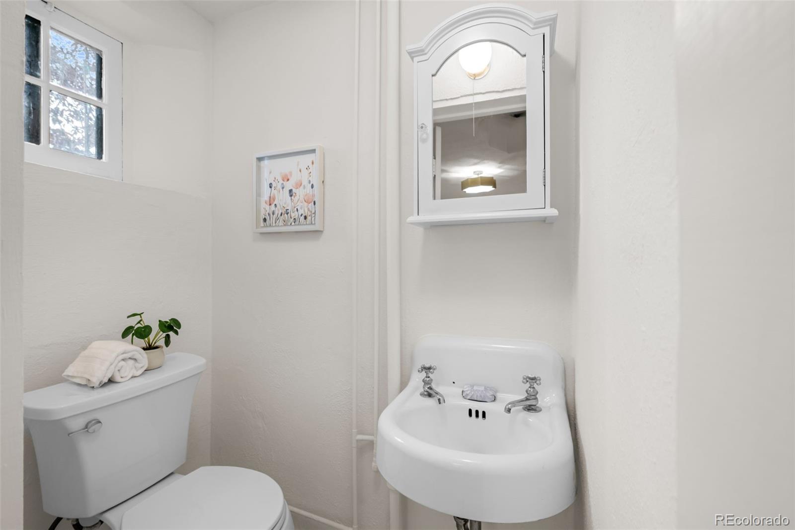 772 16th Street Boulder, CO 80302 - Photo 24 of 26 a bathroom with a toilet sink and mirror