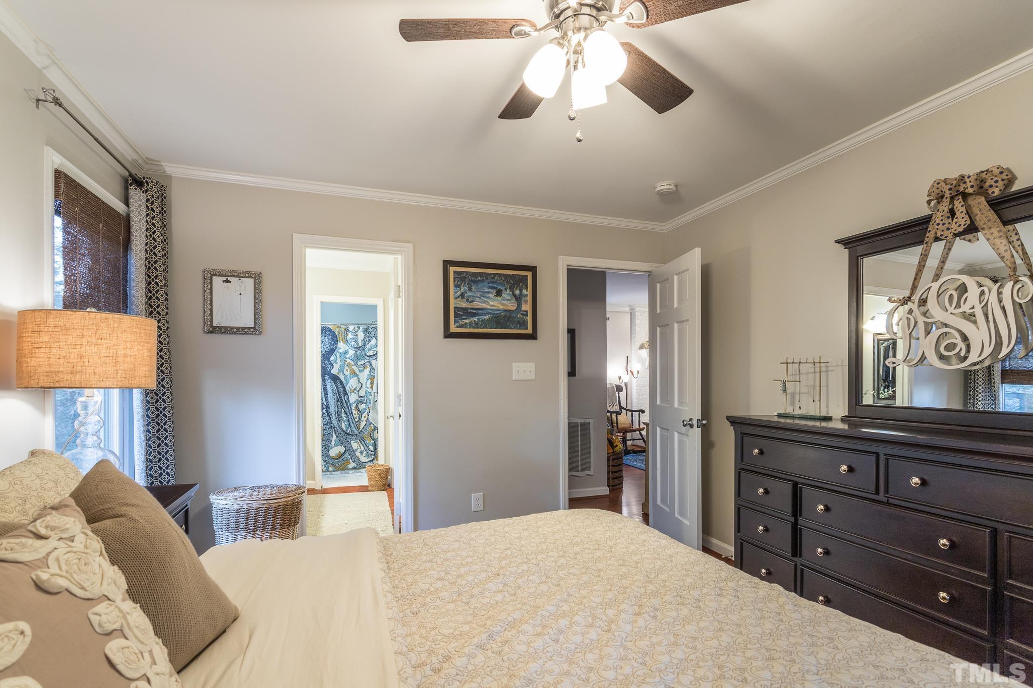 6924 Glendower Road Raleigh, NC 27613 - Photo 13 of 27 a bedroom with a bed and a chandelier