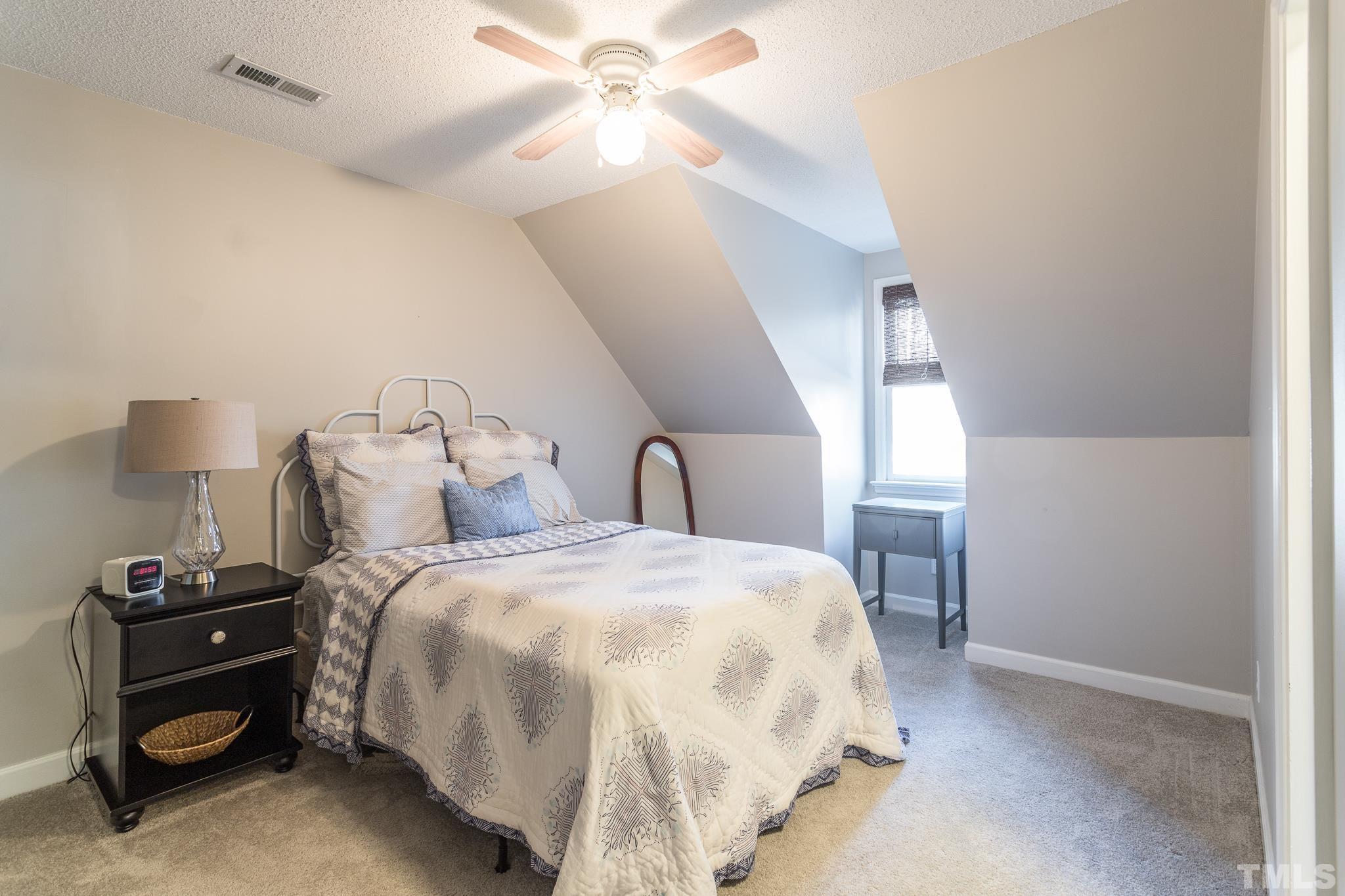 6924 Glendower Road Raleigh, NC 27613 - Photo 19 of 27 a bedroom with a bed and a chandelier