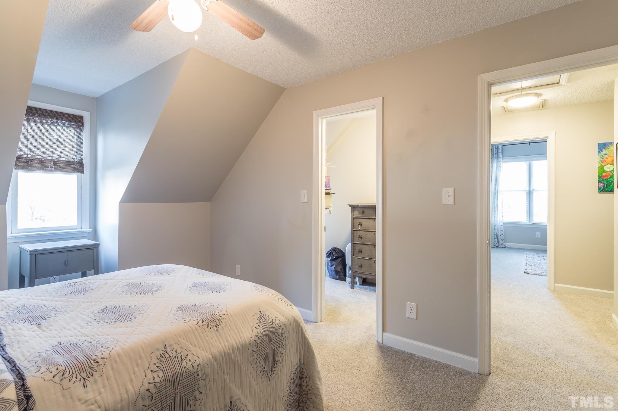 6924 Glendower Road Raleigh, NC 27613 - Photo 20 of 27 a bedroom with a bed and a chandelier