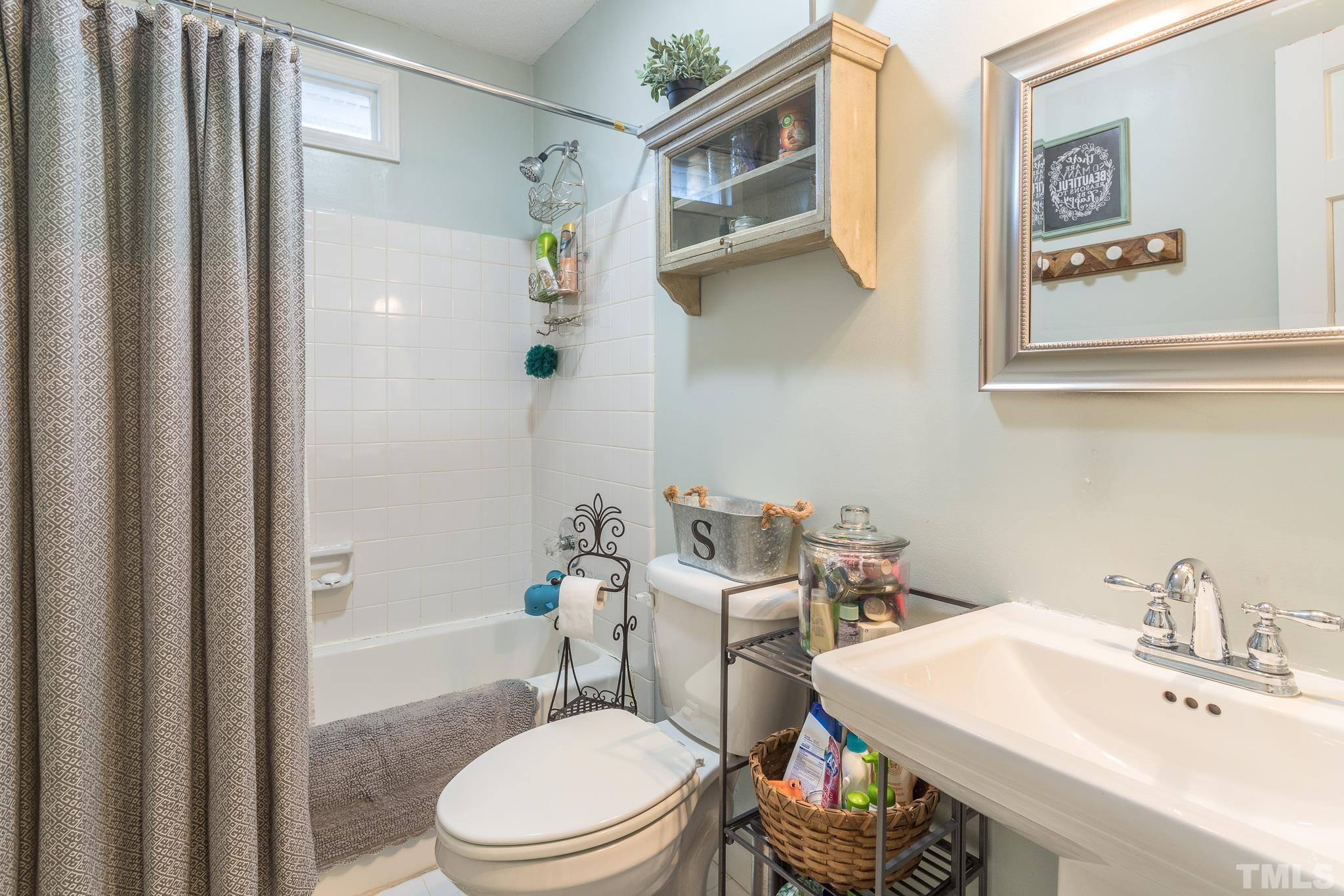 6924 Glendower Road Raleigh, NC 27613 - Photo 23 of 27 a bathroom with a sink a toilet and shower curtain
