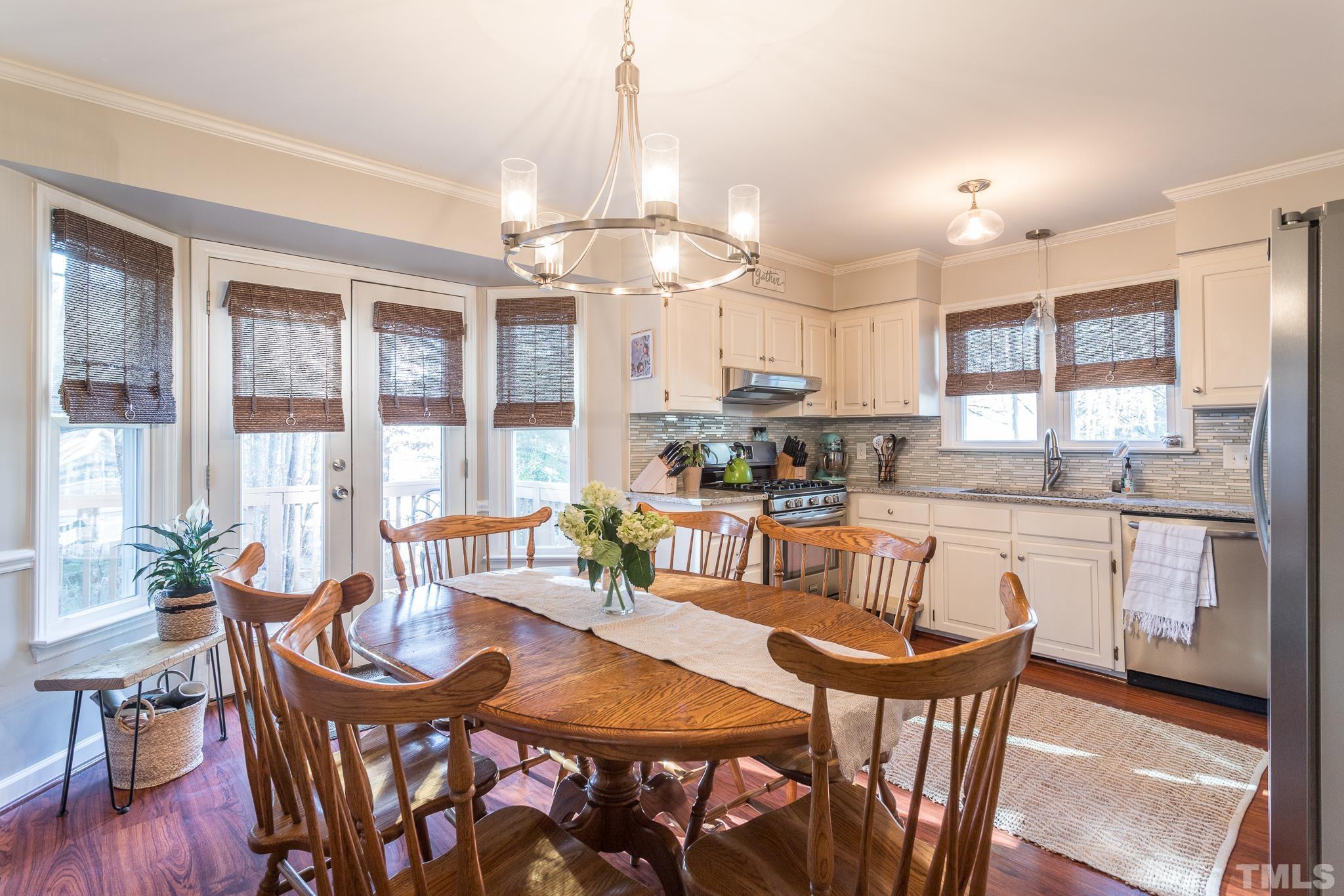 6924 Glendower Road Raleigh, NC 27613 - Photo 5 of 27 a view of a dining room with furniture a chandelier and wooden floor