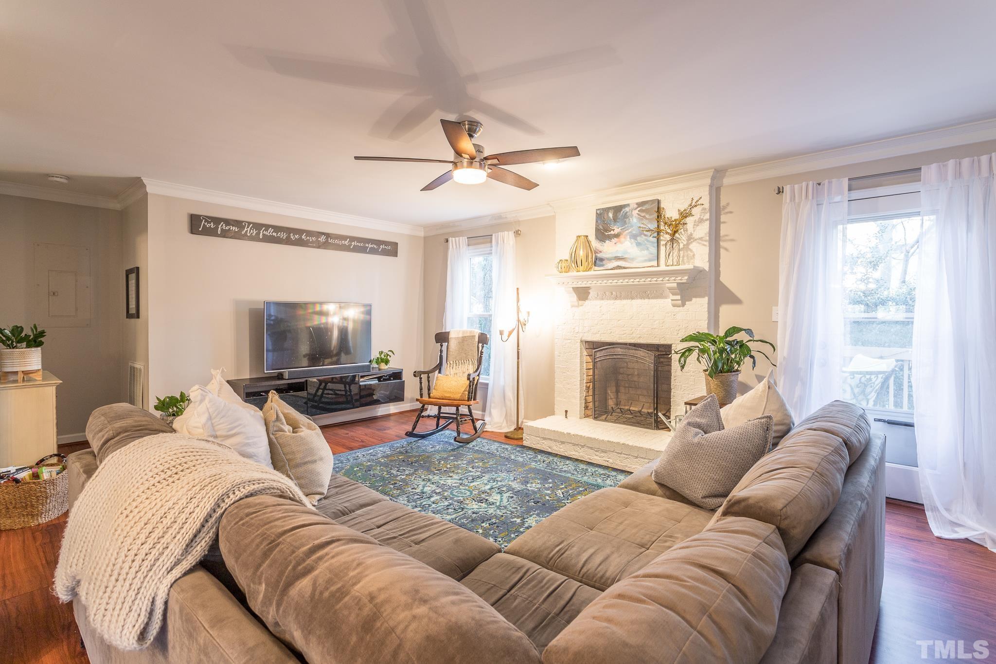 6924 Glendower Road Raleigh, NC 27613 - Photo 10 of 27 a living room with furniture a fireplace and a flat screen tv