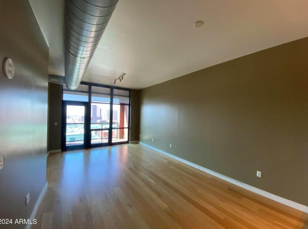 310 South 4th Street, Unit 1602 Phoenix, AZ 85004 - Photo 3 of 20 an empty room with wooden floor and windows