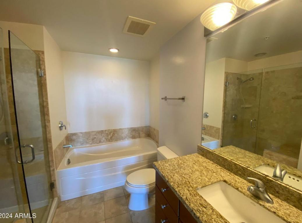 310 South 4th Street, Unit 1602 Phoenix, AZ 85004 - Photo 8 of 20 a bathroom with a granite countertop bathtub sink vanity mirror and toilet