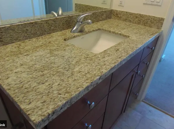 a bathroom with a granite countertop sink and a mirror