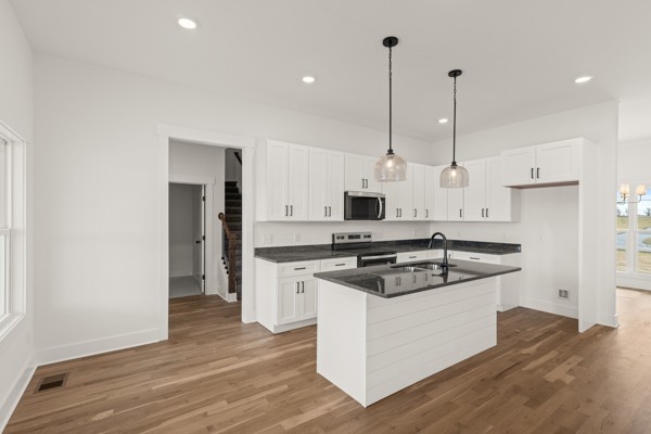 5558 Borthick Road Springfield, TN 37172 - Photo 13 of 43 a kitchen with stainless steel appliances granite countertop a sink a stove a refrigerator and white cabinets with wooden floor