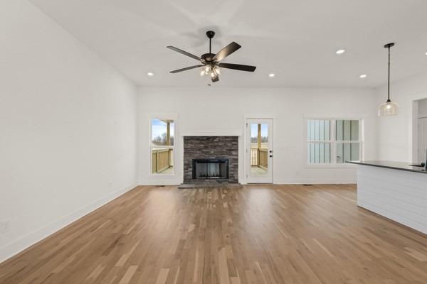5558 Borthick Road Springfield, TN 37172 - Photo 9 of 43 a view of a livingroom with a fireplace a ceiling fan and wooden floor