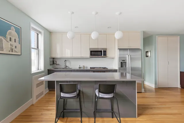 a kitchen with stainless steel appliances granite countertop a stove a sink dishwasher a dining table and chairs with wooden floor