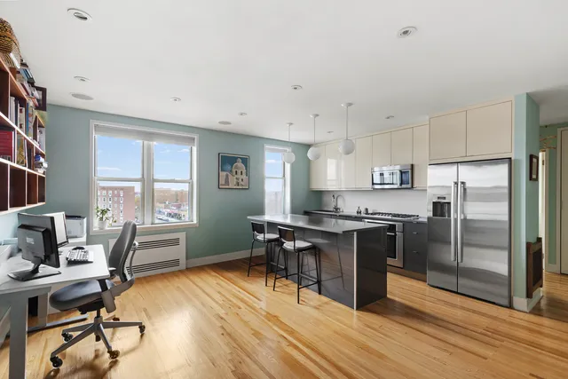 a kitchen with stainless steel appliances granite countertop a refrigerator a stove a sink dishwasher a dining table and chairs with wooden floor