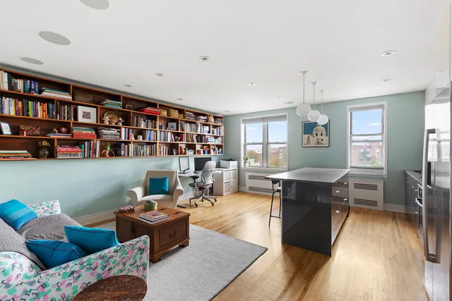 a kitchen with stainless steel appliances a stove a refrigerator a dining table and chairs with wooden floor