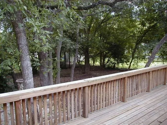a view of balcony with wooden floor and fence