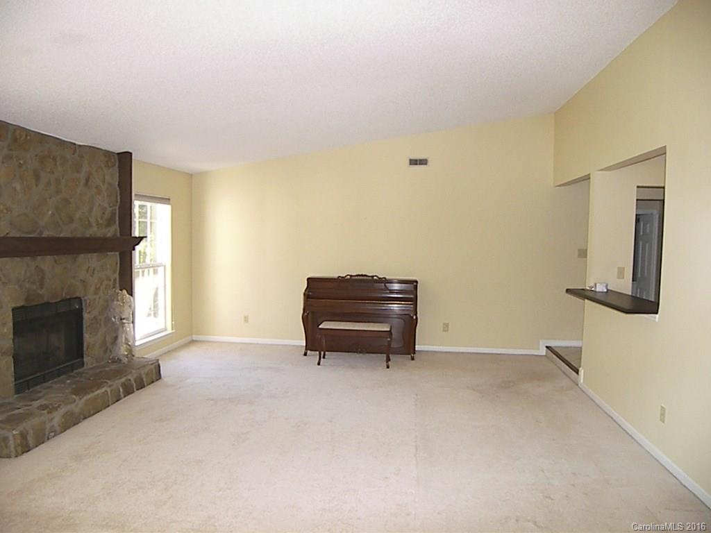 9913 Fairway Ridge Road Charlotte, NC 28277 - Photo 5 of 18 a room with a fireplace and a chair