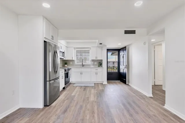 a kitchen with white cabinets and stainless steel appliances
