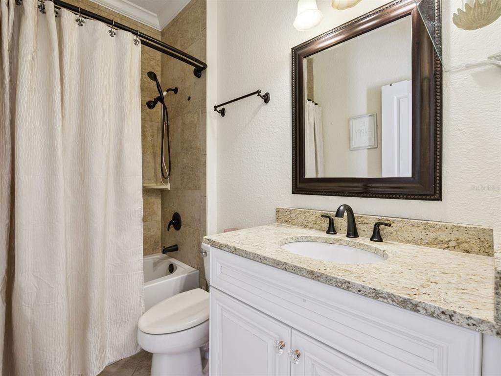 13403 Riggs Way Windermere, FL 34786 - Photo 25 of 47 a bathroom with a granite countertop sink a toilet and a mirror