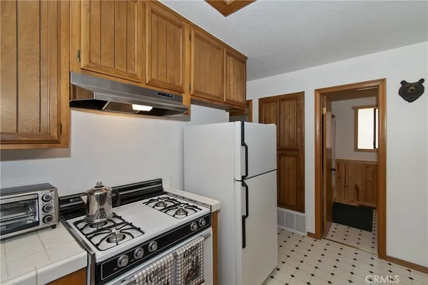 a kitchen with stainless steel appliances a refrigerator and a stove top oven