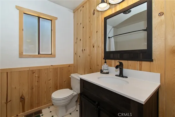 a bathroom with a sink vanity mirror and toilet