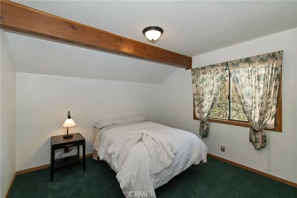 a bed sitting in a bedroom next to a window