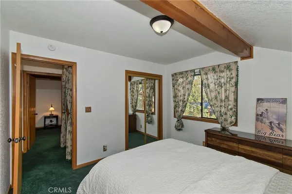a bedroom with a bed and a large window with outer view