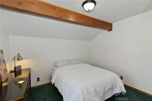 a bed sitting in a bedroom next to a window
