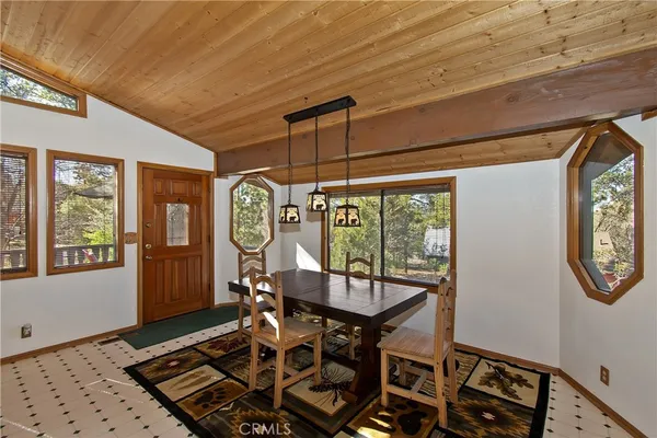 a dining room with wooden floor a glass table and chairs