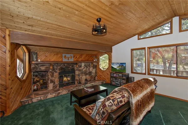 a living room with furniture a flat screen tv and a floor to ceiling window