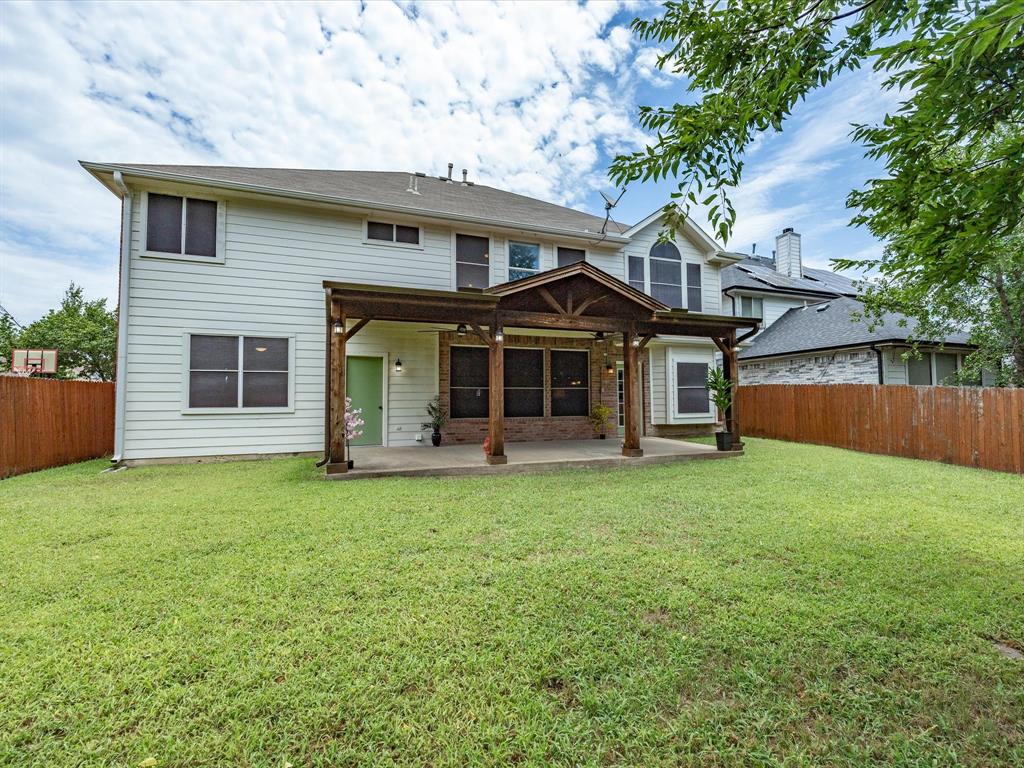 4008 Falcon Ridge Drive Haltom City, TX 76137 - Photo 37 of 40 Expansive backyard with a covered patio featuring a wood pergola, concrete flooring, and brick accents