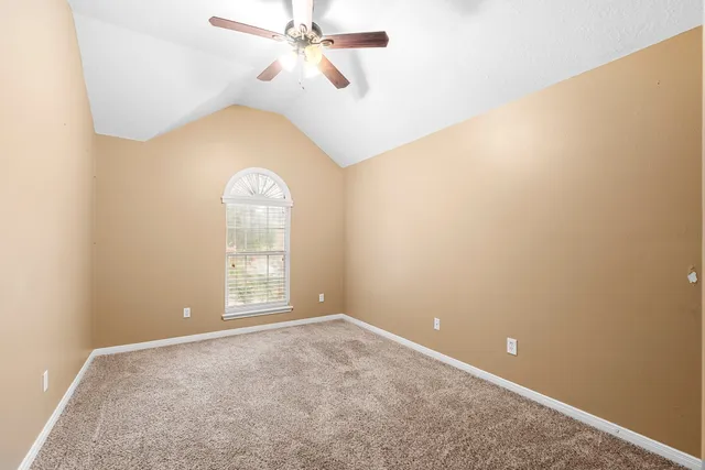 an empty room with a window and a ceiling fan