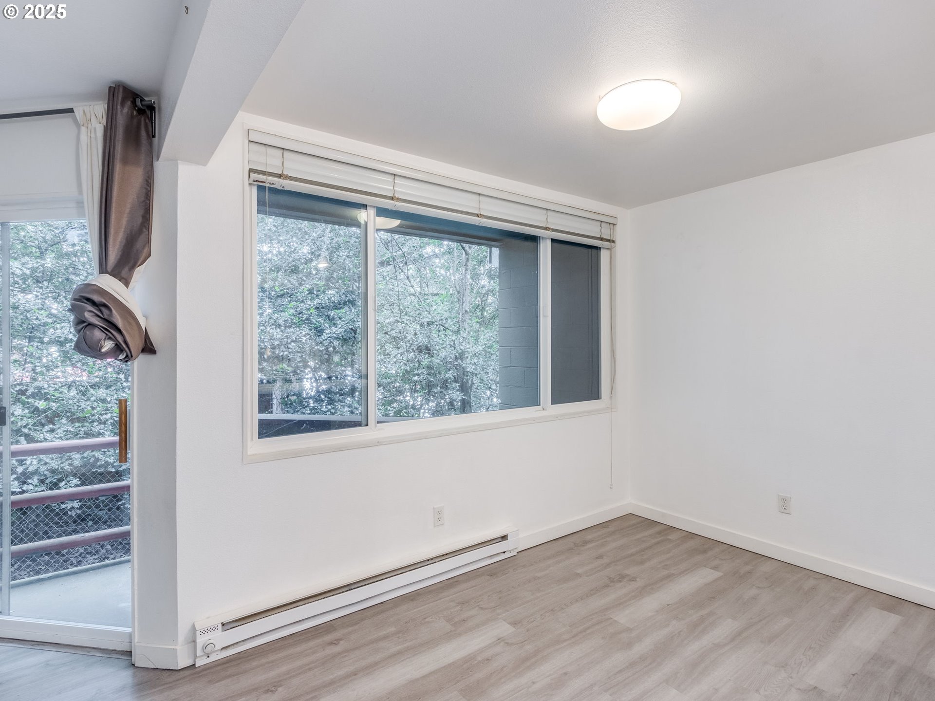 6220 Southwest Capitol Highway, Unit 7 Portland, OR 97239 - Photo 17 of 31 an empty room with wooden floor and windows