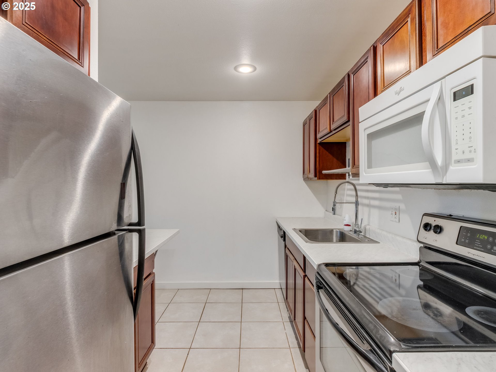 6220 Southwest Capitol Highway, Unit 7 Portland, OR 97239 - Photo 20 of 31 a kitchen with stainless steel appliances granite countertop a sink stove and refrigerator