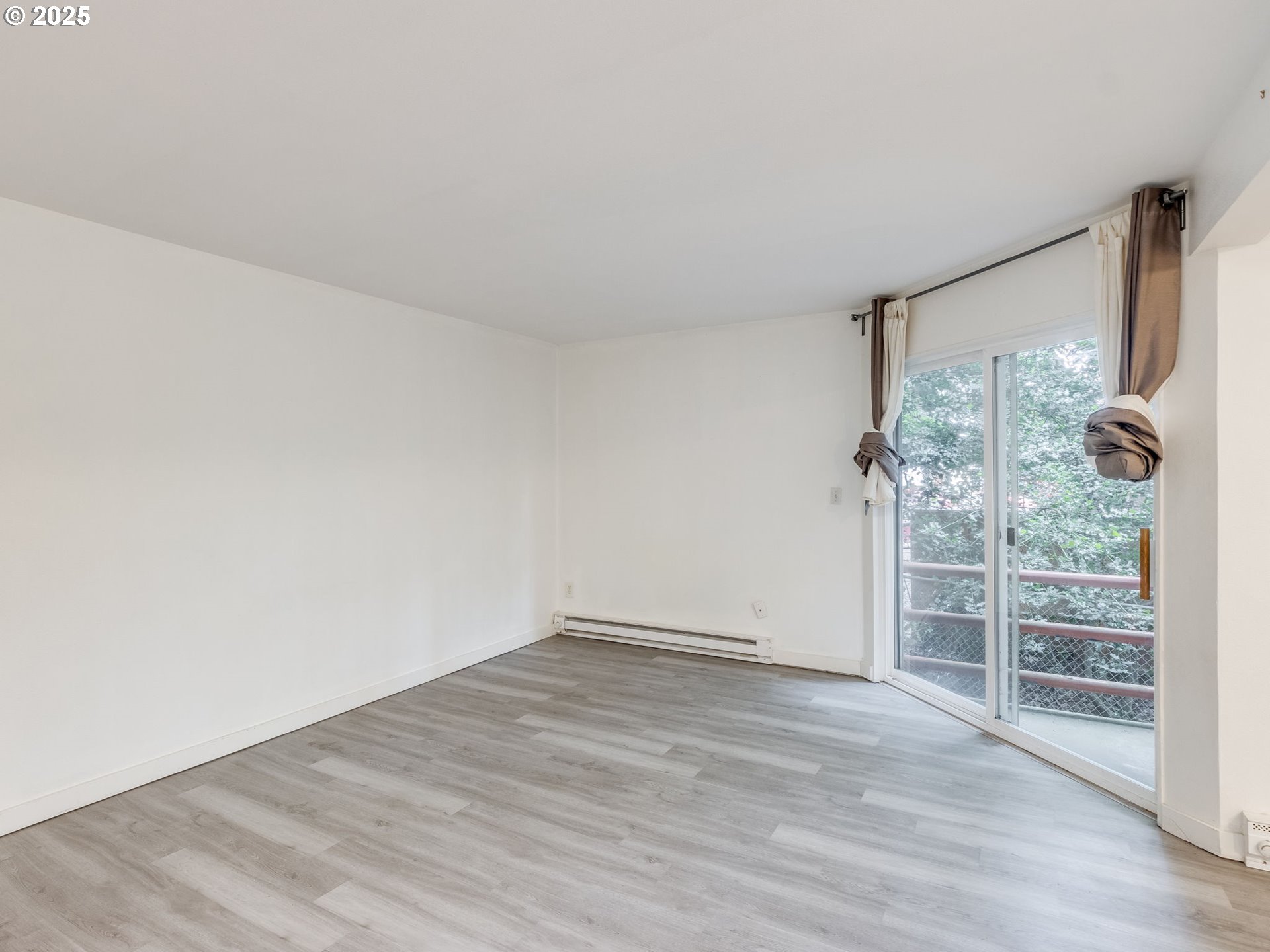 6220 Southwest Capitol Highway, Unit 7 Portland, OR 97239 - Photo 8 of 31 an empty room with wooden floor and windows