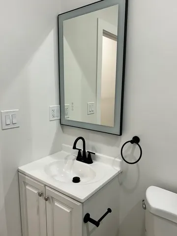 a bathroom with a toilet a sink and mirror