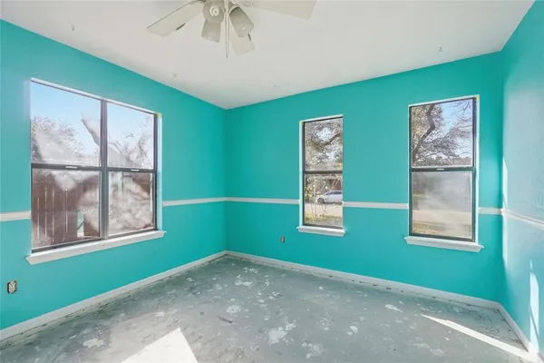 a view of empty room with window and fan