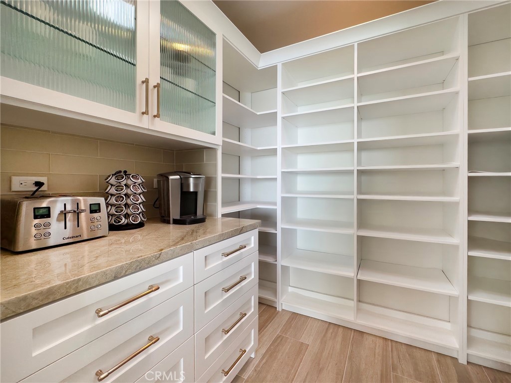 33971 Nauticus Isle Dana Point, CA 92629 - Photo 11 of 27 a kitchen with a wooden floor and cabinets