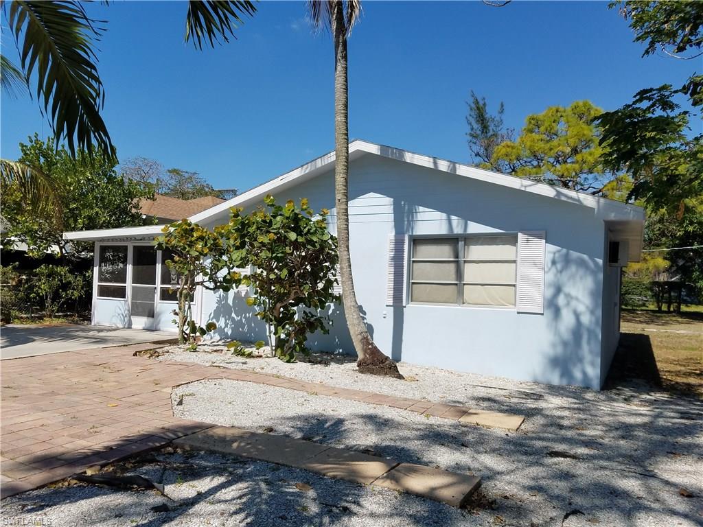 1009 Ridge Street Naples, FL 34103 - Photo 3 of 10 a front view of a house with a yard and garage