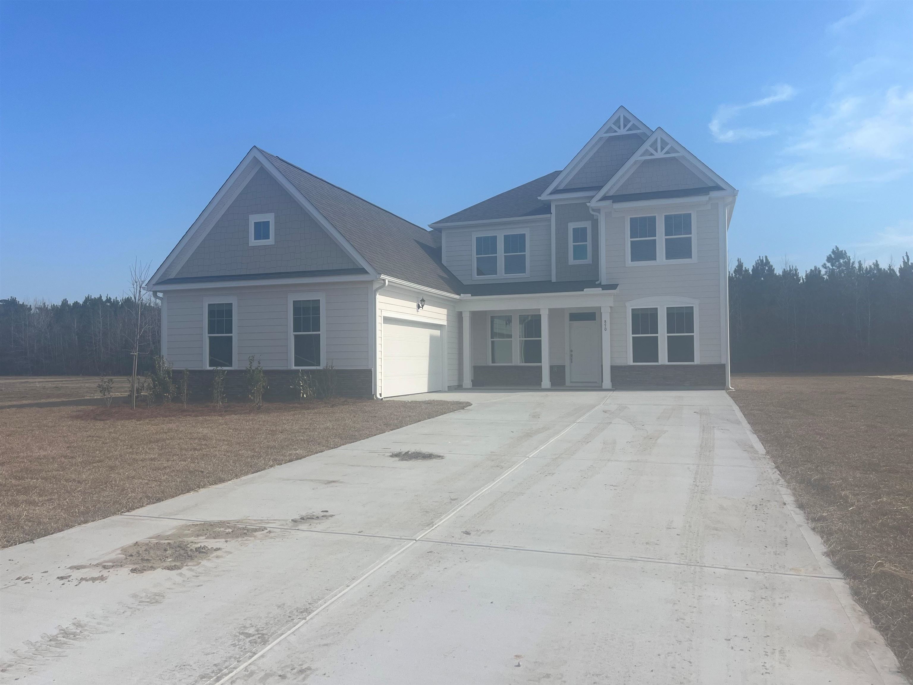 View of front of property with concrete driveway and covered porch