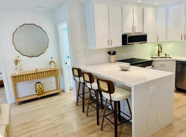 a kitchen with a dining table cabinets and a wooden floor