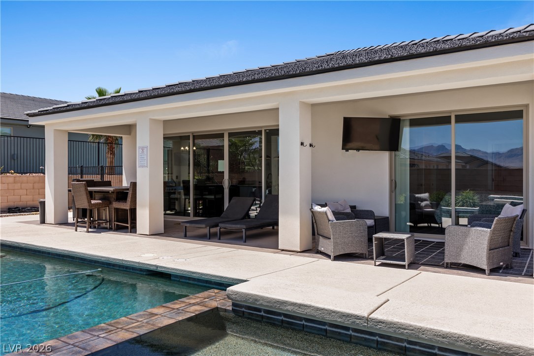 1436 Manassas Ridge Mesquite, NV 89027 - Photo 55 of 77 An inviting outdoor living area awaits, complete with a pool and covered patio for ultimate relaxation.