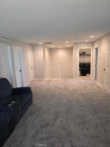 a living room with furniture and a refrigerator