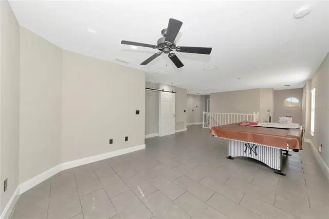 a living room with a bed and ceiling fan