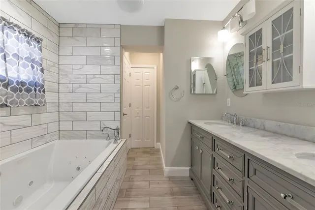 a bathroom with a tub sink and mirror